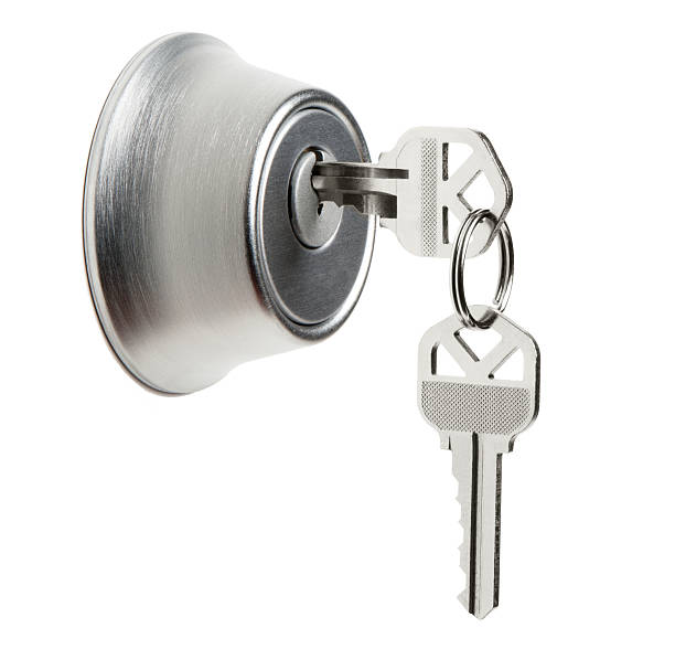 Close-up of a silver door lock with a key inserted, accompanied by additional keys on a ring, representing a master key system for residential security.