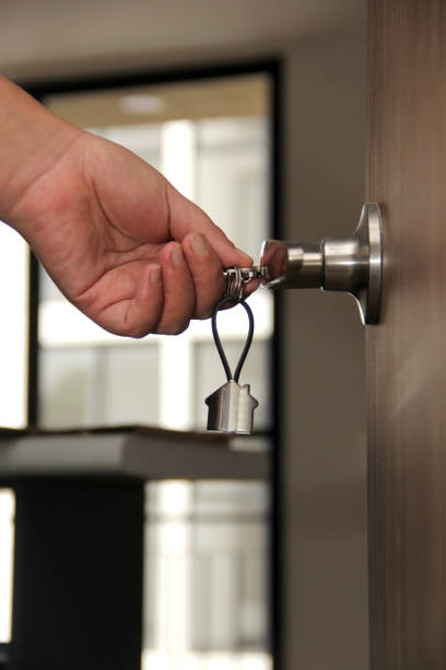 A man holds a key to a newly rekeyed door lock. Call 512 Locksmith for a Residential Rekey Services in Austin, Texas.