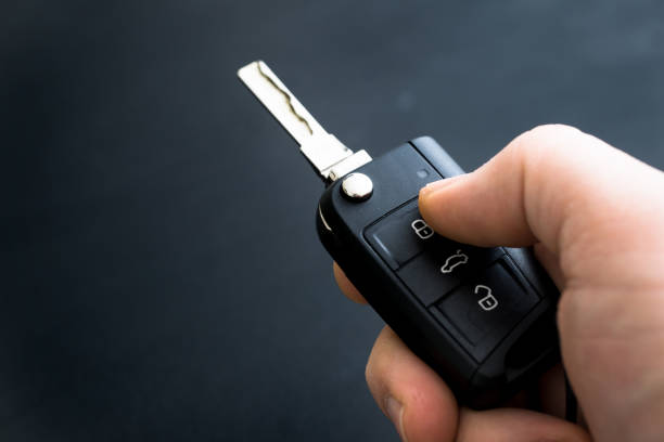 Car Remote Control Key In Hand With Black Background Car Key Fob Programming in Burnet TX