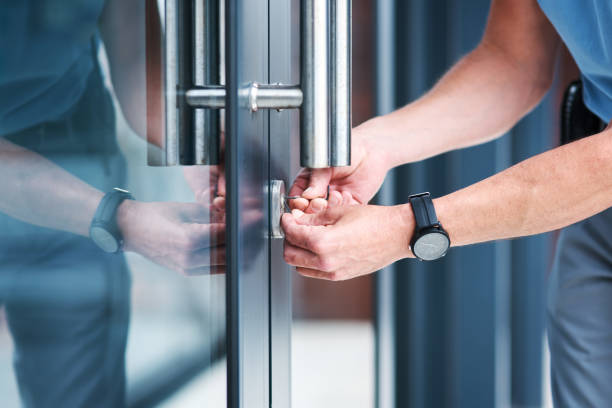 Shot Of An Unrecognizable Male Locksmith Installing A Lock Commercial Locksmith is working on commercial door Austin TX