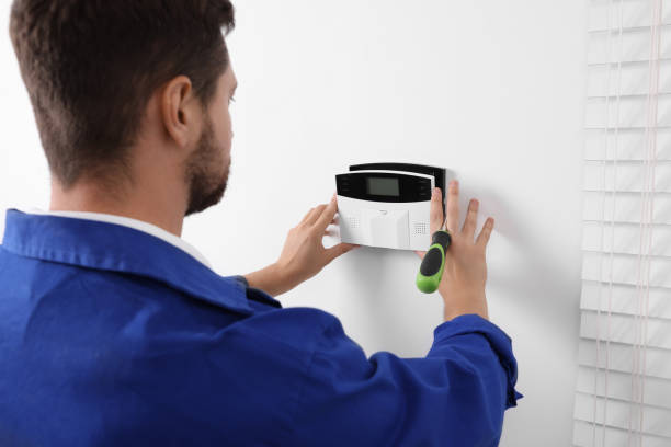 Technician Installing Home Security Alarm System On White Wall Indoors Keyless Entry Lock was reapired by Emergency Locksmith Service in Pflugerville TX